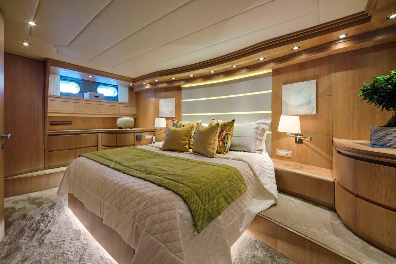 The master stateroom features a luxurious bed with elegant lighting and warm wooden finishes. aboard AMAYA Yacht for Sale