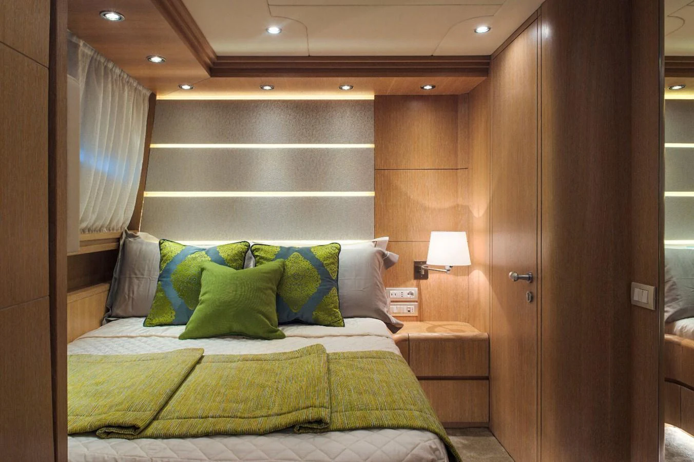 The stateroom features a cozy bed with elegant wooden paneling and soft lighting. aboard AMAYA Yacht for Sale