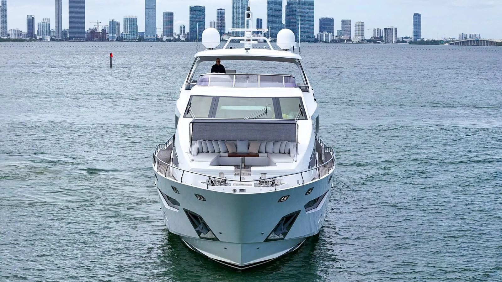 A sleek yacht cruising on the water with a city skyline in the background. aboard 2017 AZIMUT 30 METRI Yacht for Sale