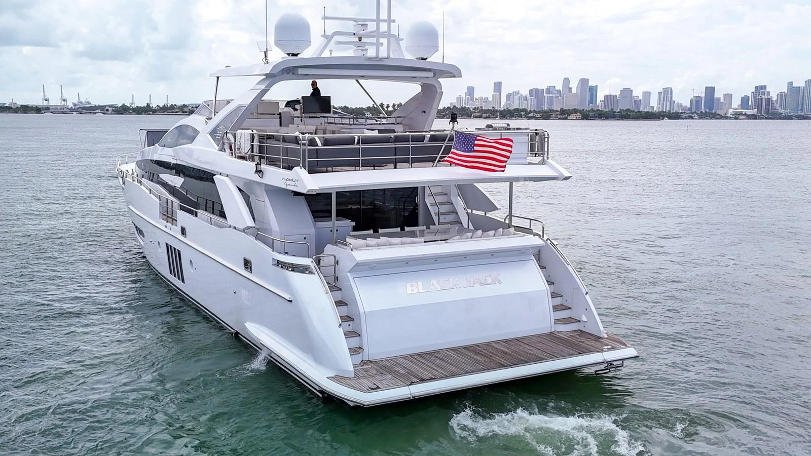 A sleek yacht cruises with a view of the city skyline in the background. aboard 2017 AZIMUT 30 METRI Yacht for Sale