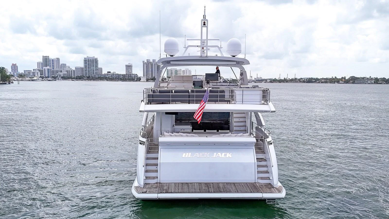 The yacht's aft deck is showcased with a view of the city skyline in the background. aboard 2017 AZIMUT 30 METRI Yacht for Sale