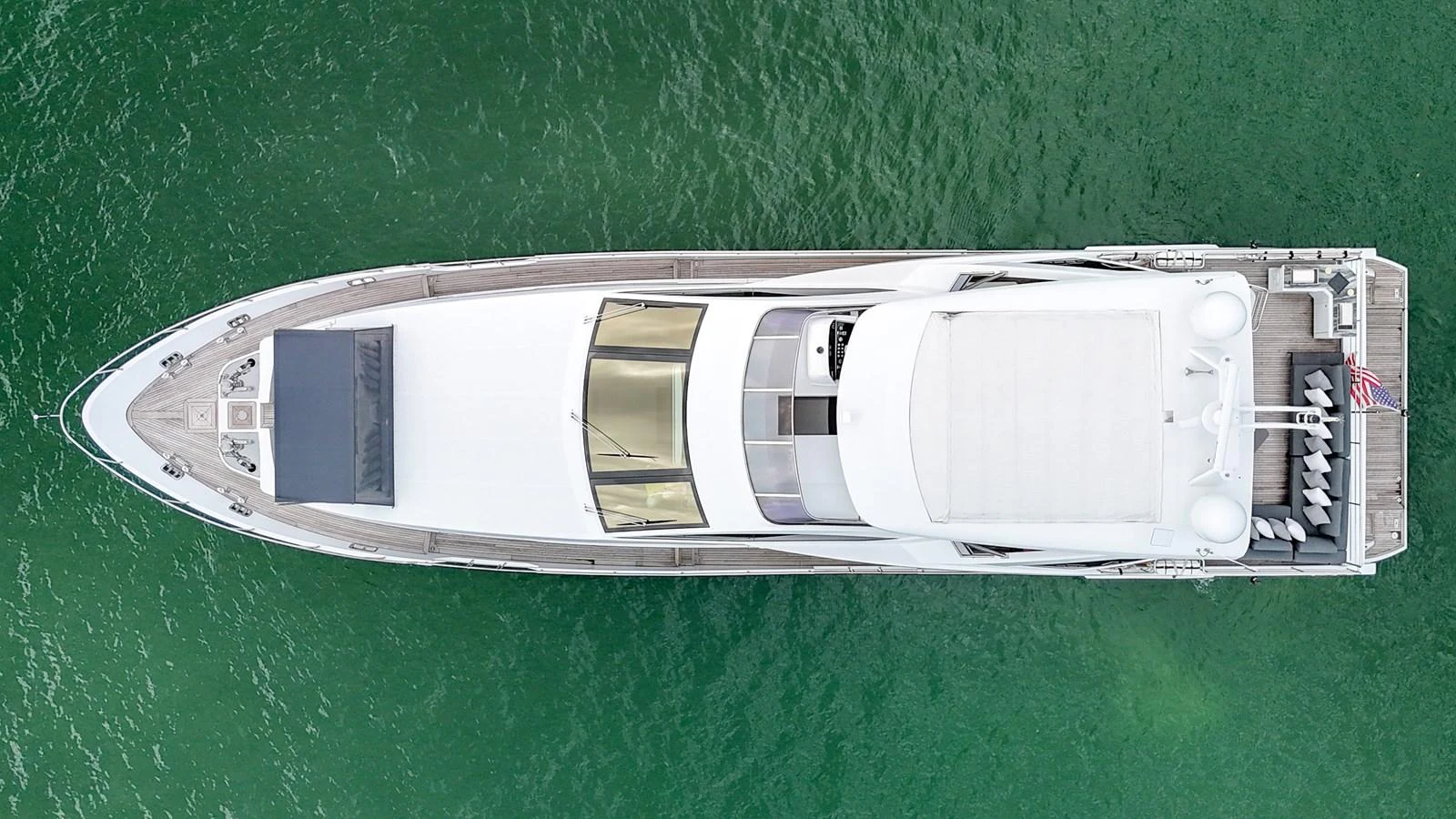 An aerial view of a sleek yacht cruising through clear green waters. aboard 2017 AZIMUT 30 METRI Yacht for Sale