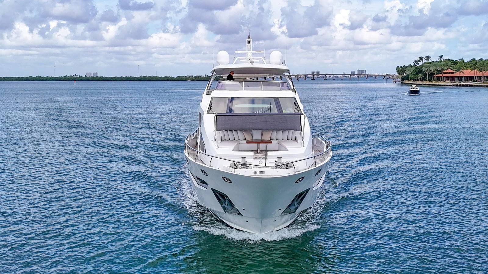 A luxurious yacht cruises forward on calm waters under a partly cloudy sky. aboard 2017 AZIMUT 30 METRI Yacht for Sale