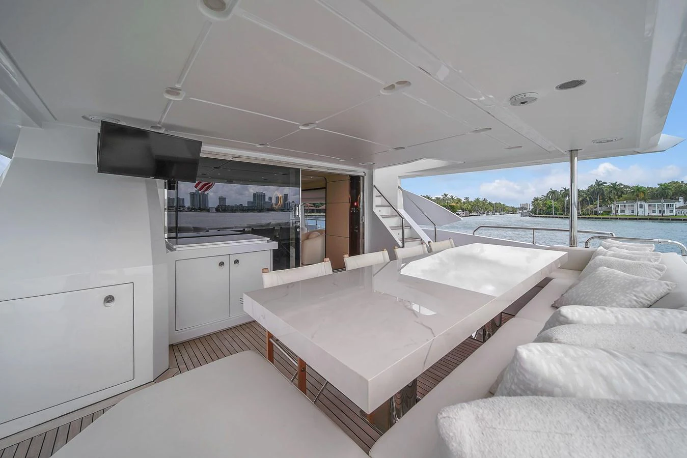 The aft deck features a spacious dining area with a sleek table and comfortable seating, perfect for alfresco meals. aboard 2017 AZIMUT 30 METRI Yacht for Sale