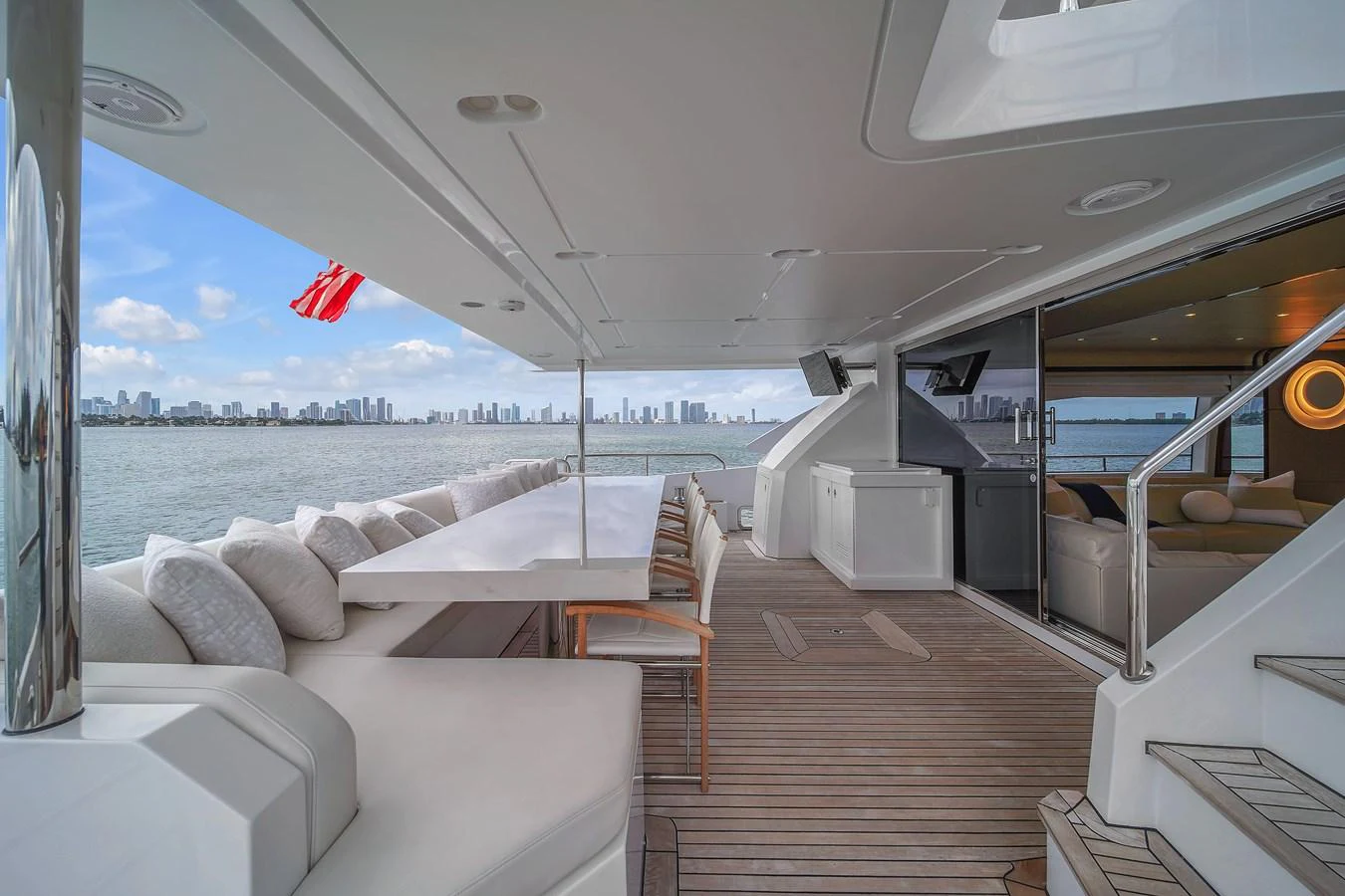 The aft deck offers a spacious and elegant outdoor dining area with a stunning view of the city skyline. aboard 2017 AZIMUT 30 METRI Yacht for Sale