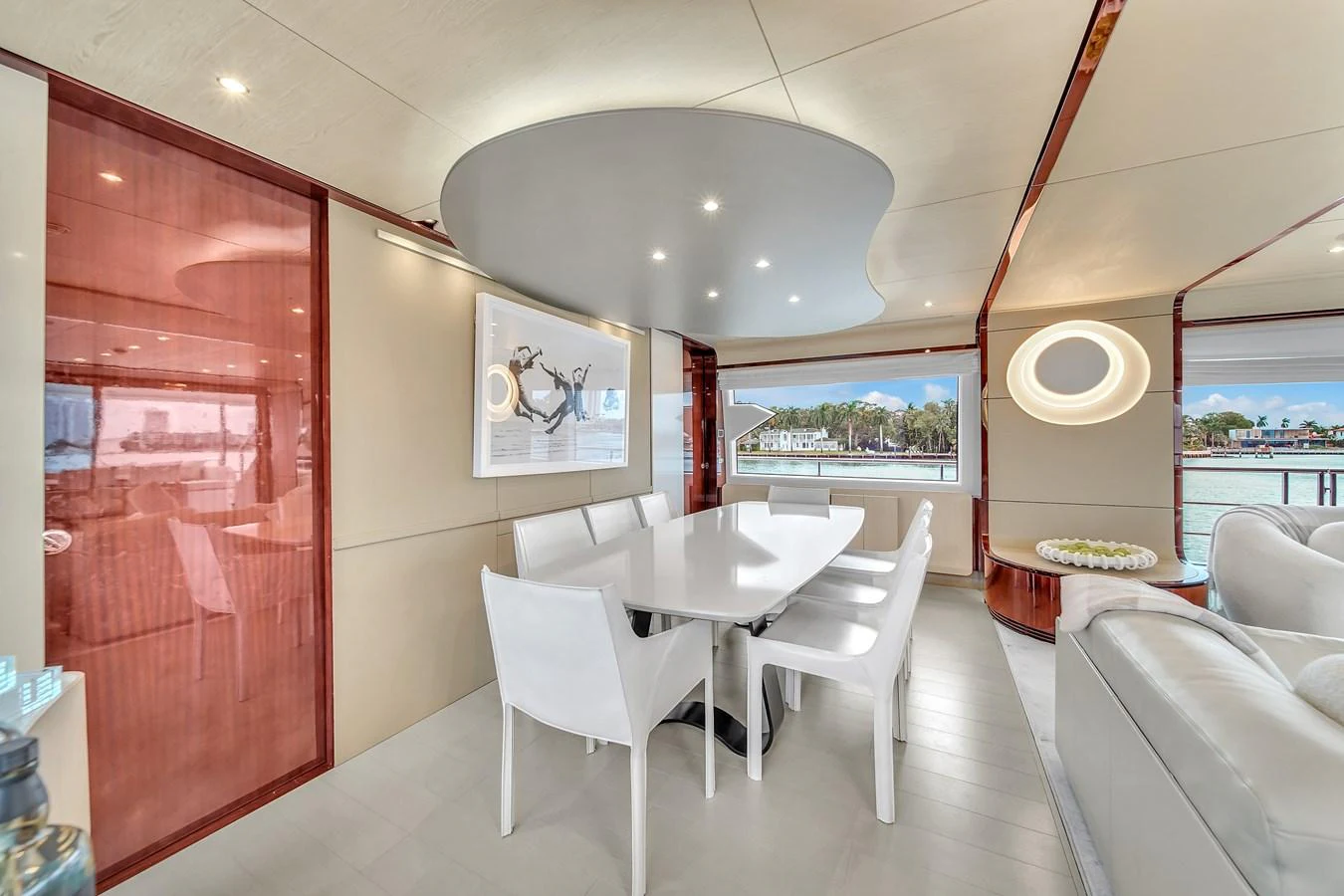The yacht's dining area features a modern table with sleek white chairs and large windows offering scenic views. aboard 2017 AZIMUT 30 METRI Yacht for Sale