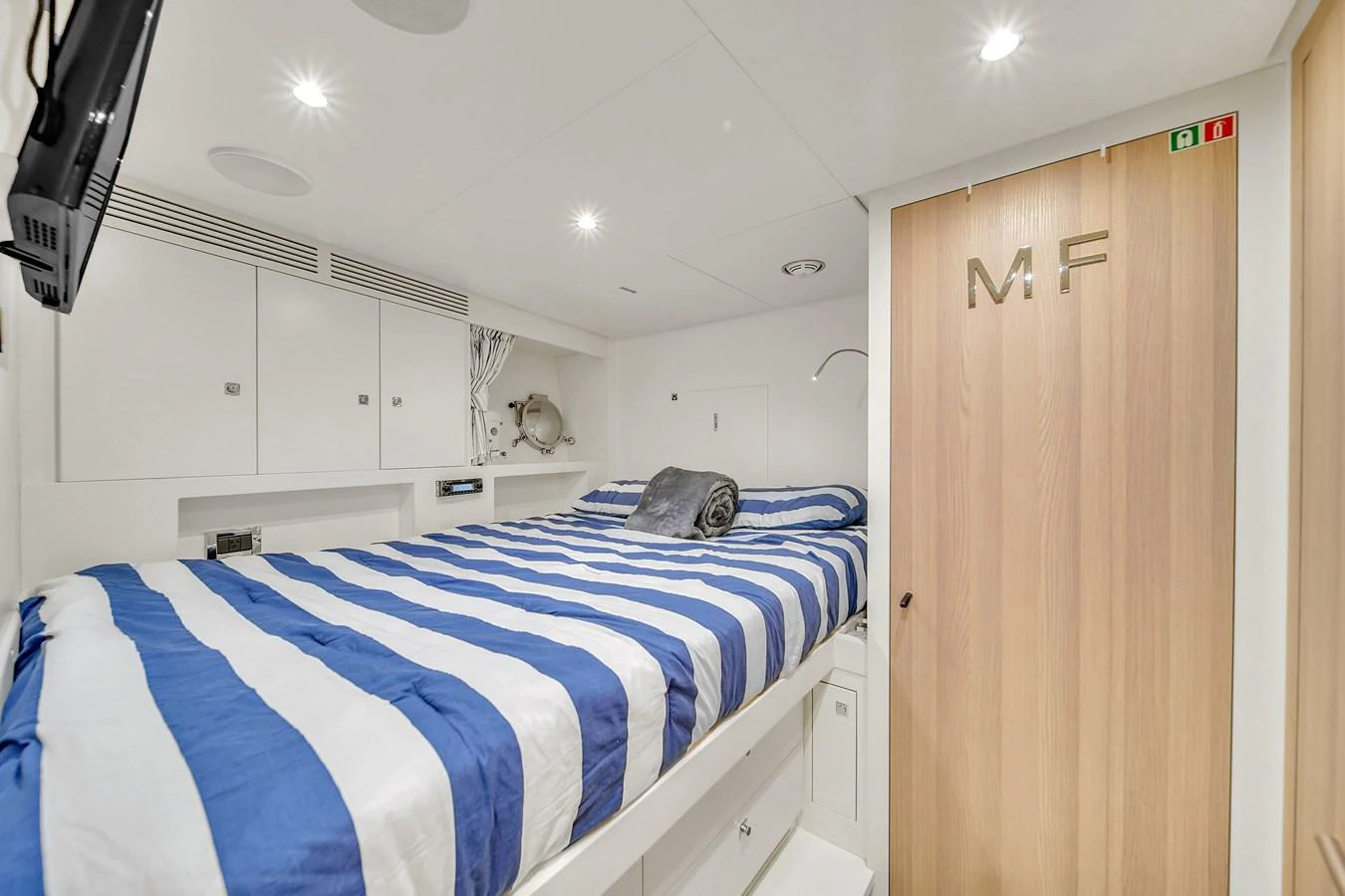The stateroom features a comfortable bed with striped bedding and modern amenities. aboard 2017 AZIMUT 30 METRI Yacht for Sale