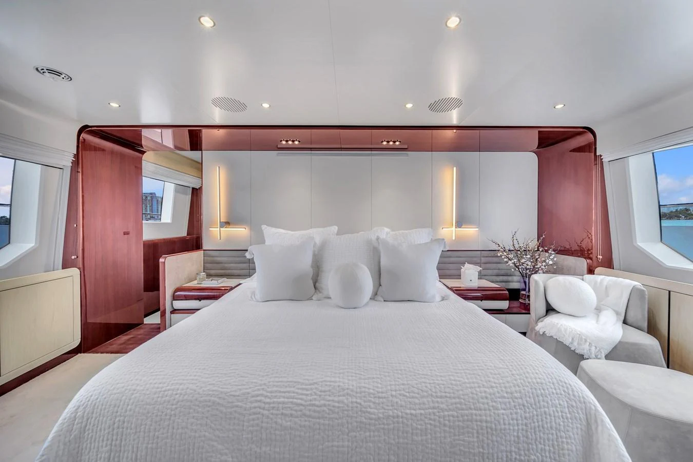 The master stateroom features a luxurious bed with plush pillows, surrounded by elegant decor and large windows offering scenic views. aboard 2017 AZIMUT 30 METRI Yacht for Sale