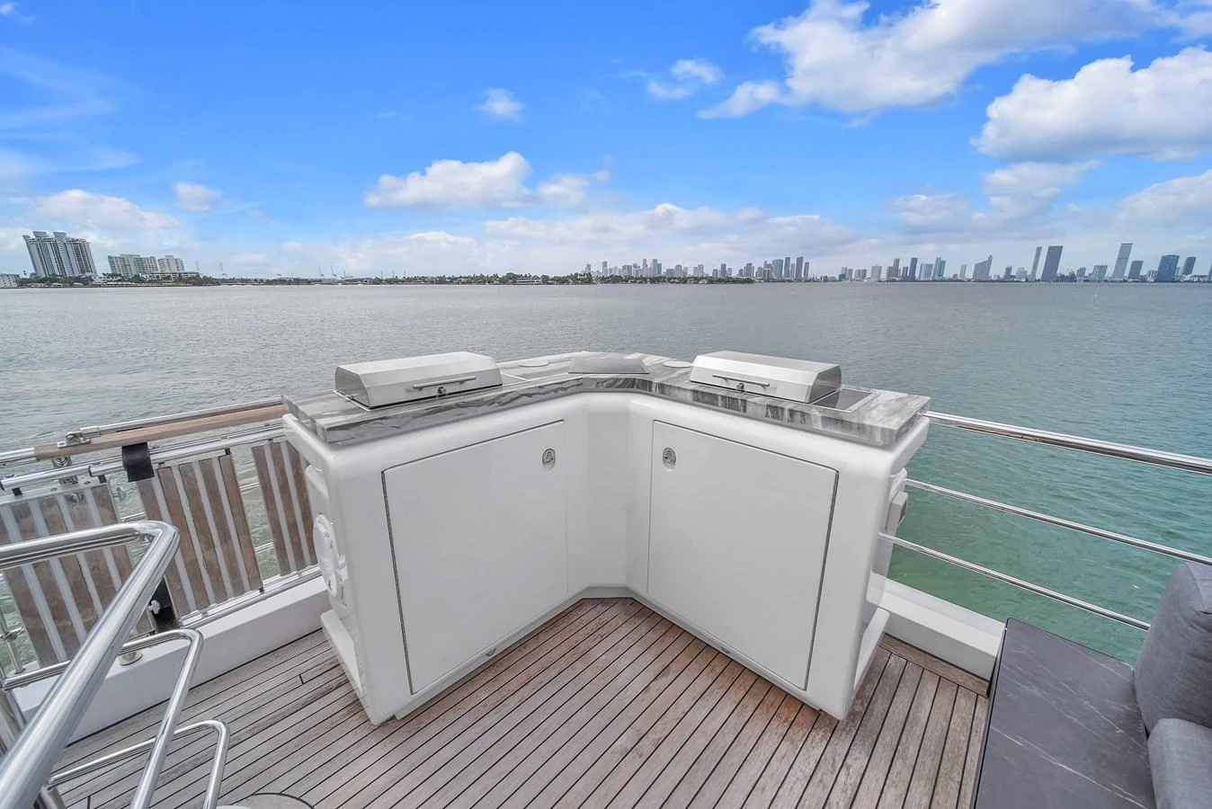 An elegant outdoor bar area on the yacht offers stunning views of the water and city skyline. aboard 2017 AZIMUT 30 METRI Yacht for Sale