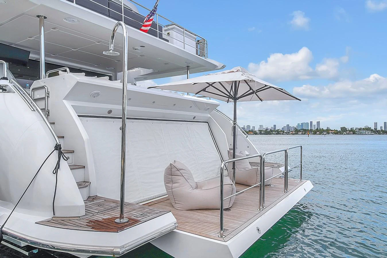 The aft deck features a relaxing area with plush seating and an umbrella, perfect for enjoying the view. aboard 2017 AZIMUT 30 METRI Yacht for Sale