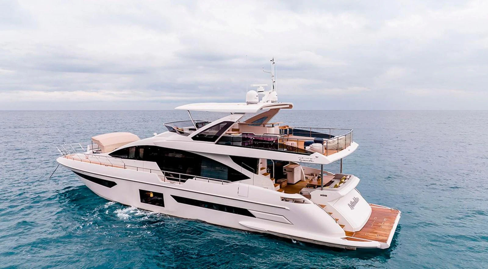 A sleek and modern yacht cruising on calm waters under a cloudy sky. aboard LASTOCHKA Yacht for Sale
