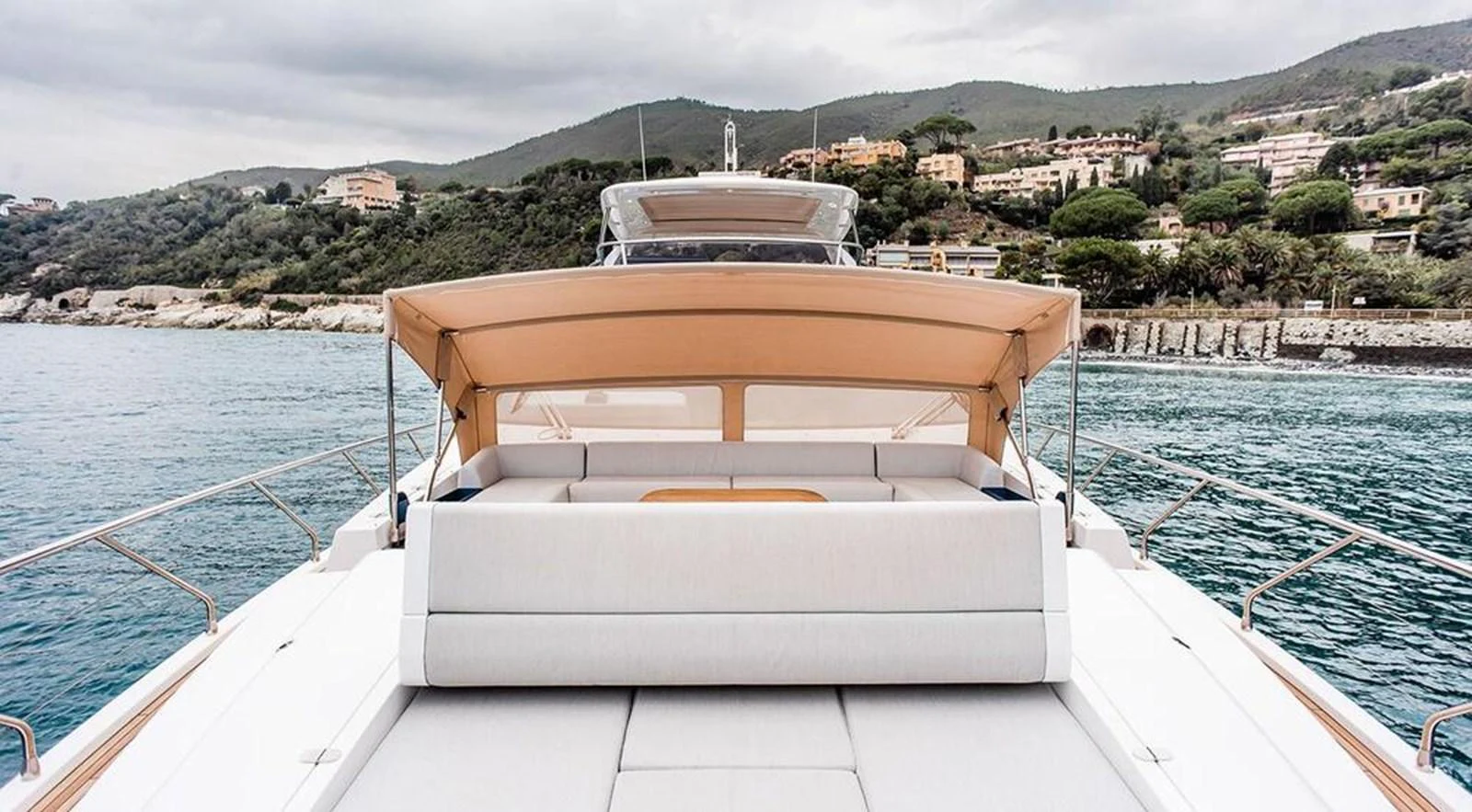 The yacht's aft deck features a spacious sunbathing area with a comfortable cushioned lounge and a retractable canopy. aboard LASTOCHKA Yacht for Sale