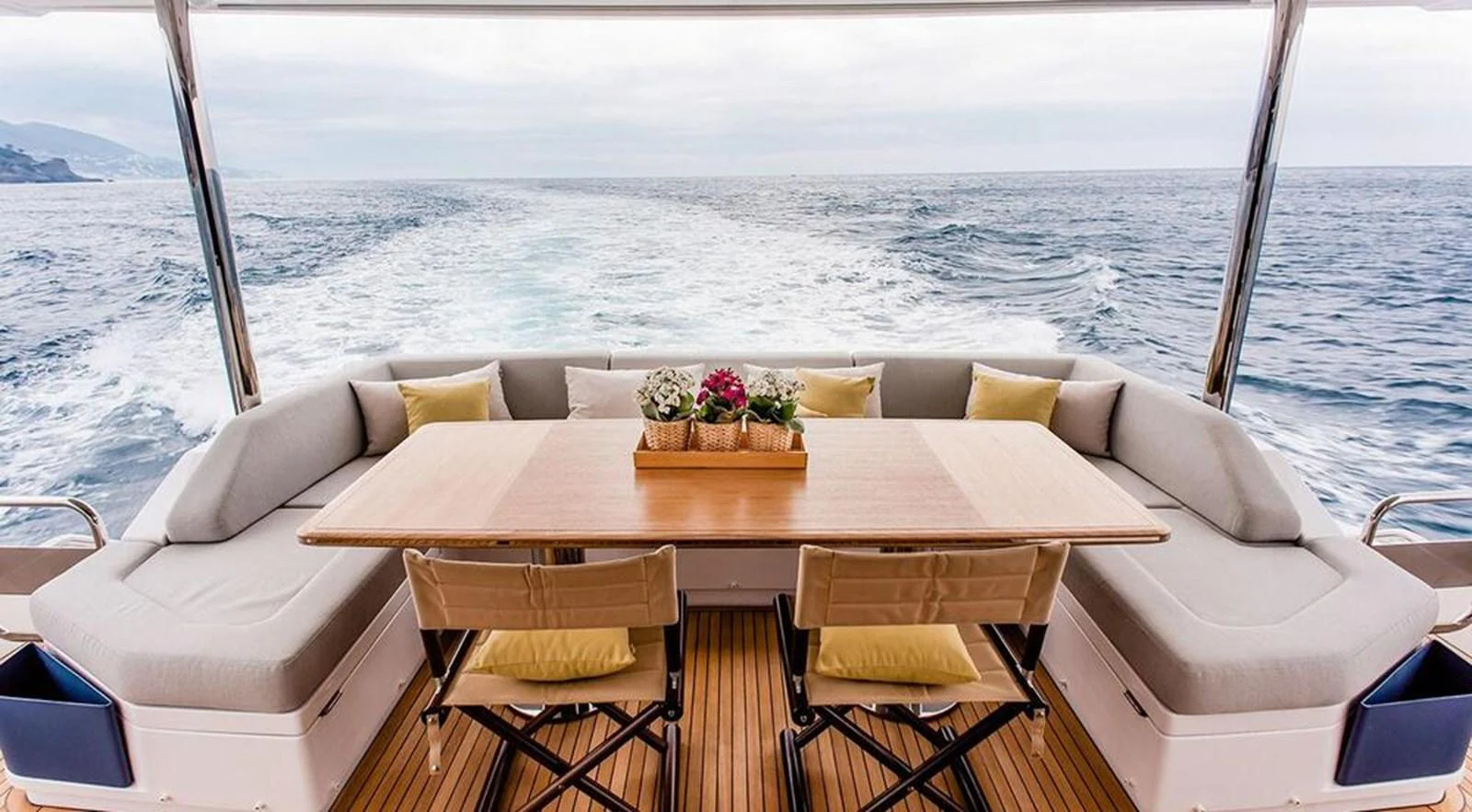 The aft deck features a cozy seating area with a wooden table, perfect for enjoying meals with a view of the open sea. aboard LASTOCHKA Yacht for Sale