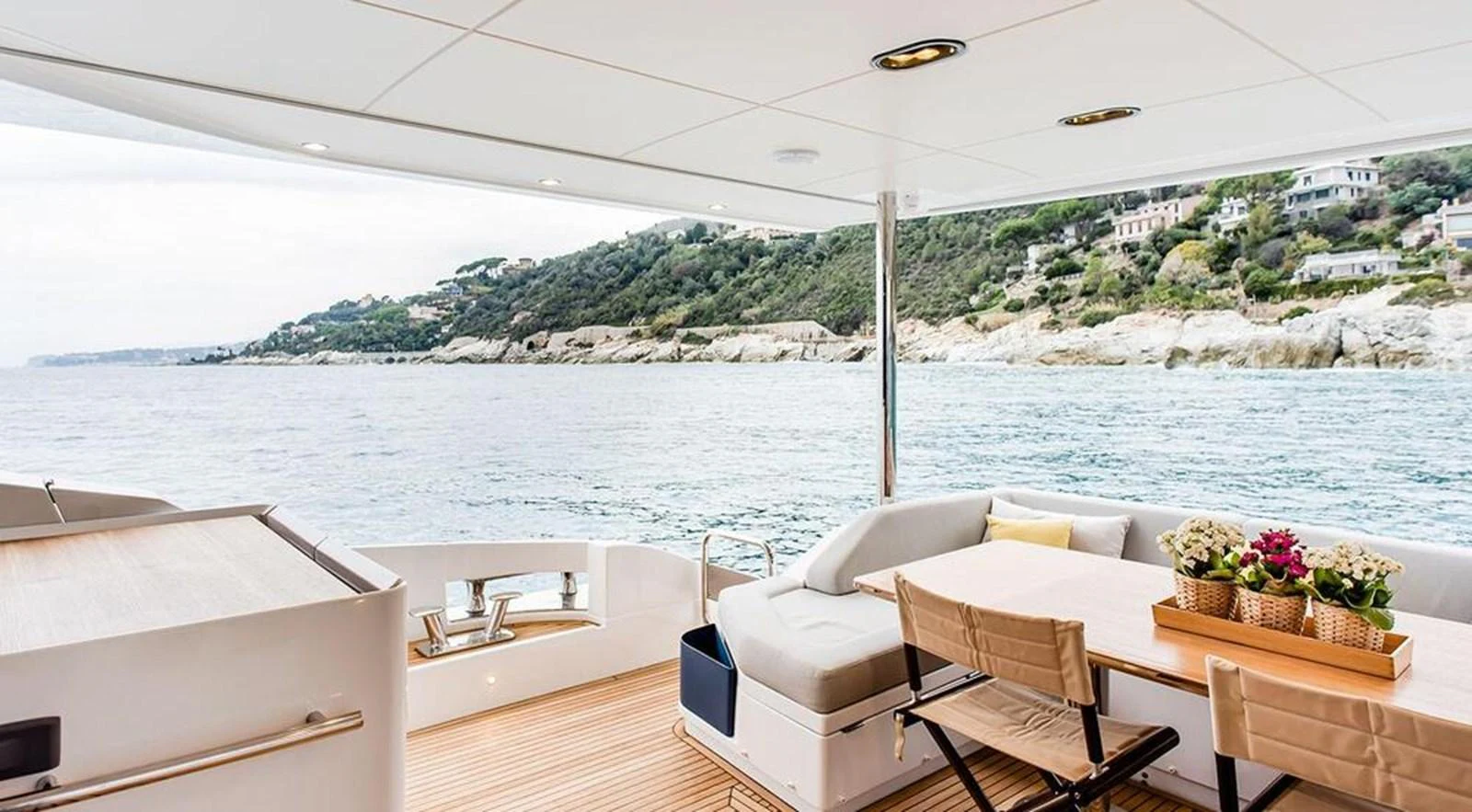 The aft deck offers a comfortable seating area with a dining table, perfect for enjoying meals with a scenic view. aboard LASTOCHKA Yacht for Sale