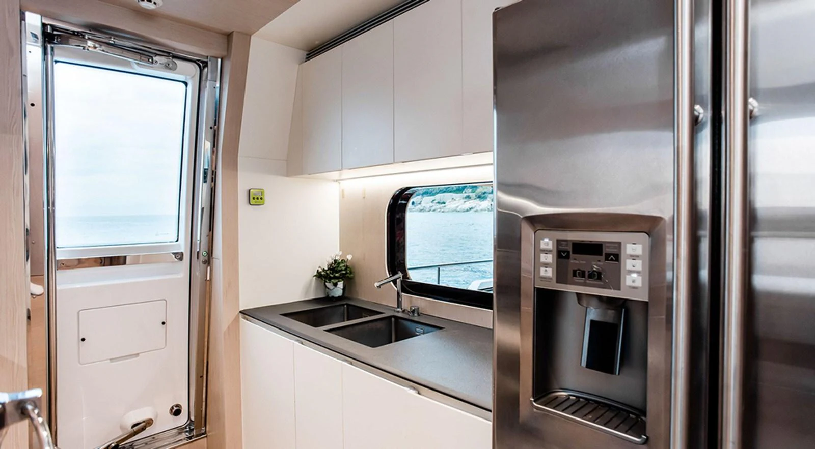 The yacht's galley is equipped with modern appliances and offers a stunning view of the sea through a large window. aboard LASTOCHKA Yacht for Sale