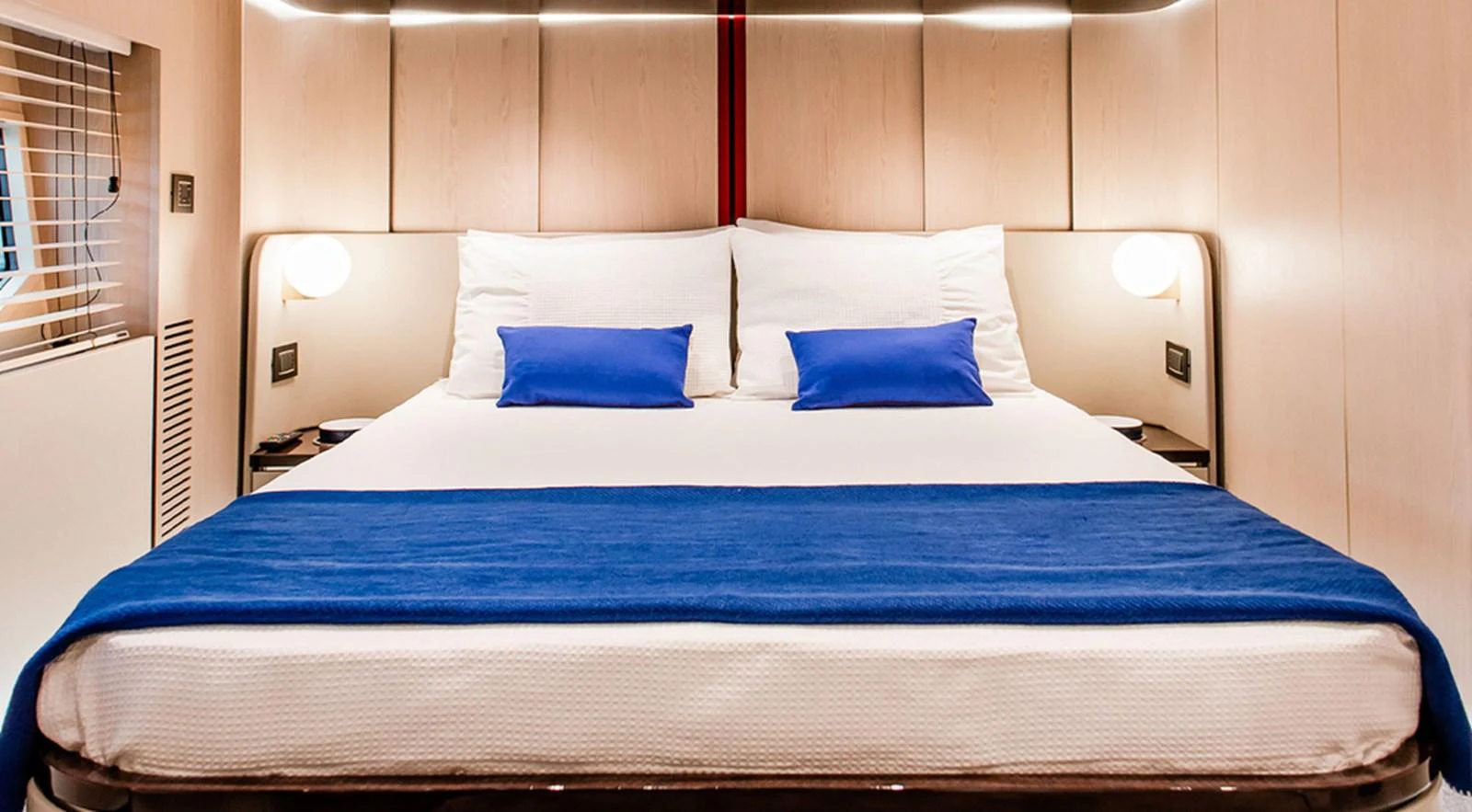 A luxurious stateroom featuring a comfortable bed with blue accents and modern lighting. aboard LASTOCHKA Yacht for Sale
