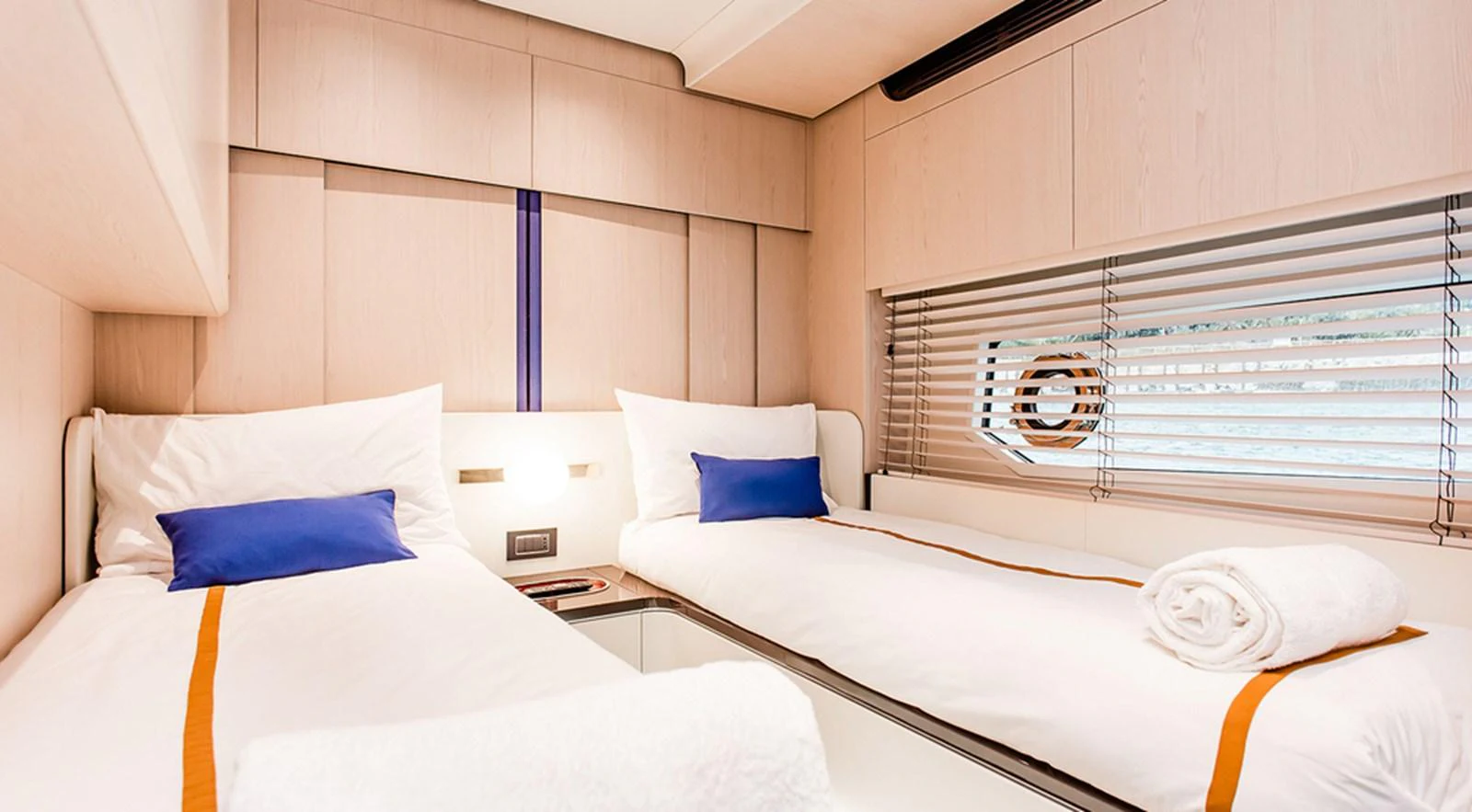 The twin stateroom features two single beds with crisp white linens and vibrant blue accents. aboard LASTOCHKA Yacht for Sale