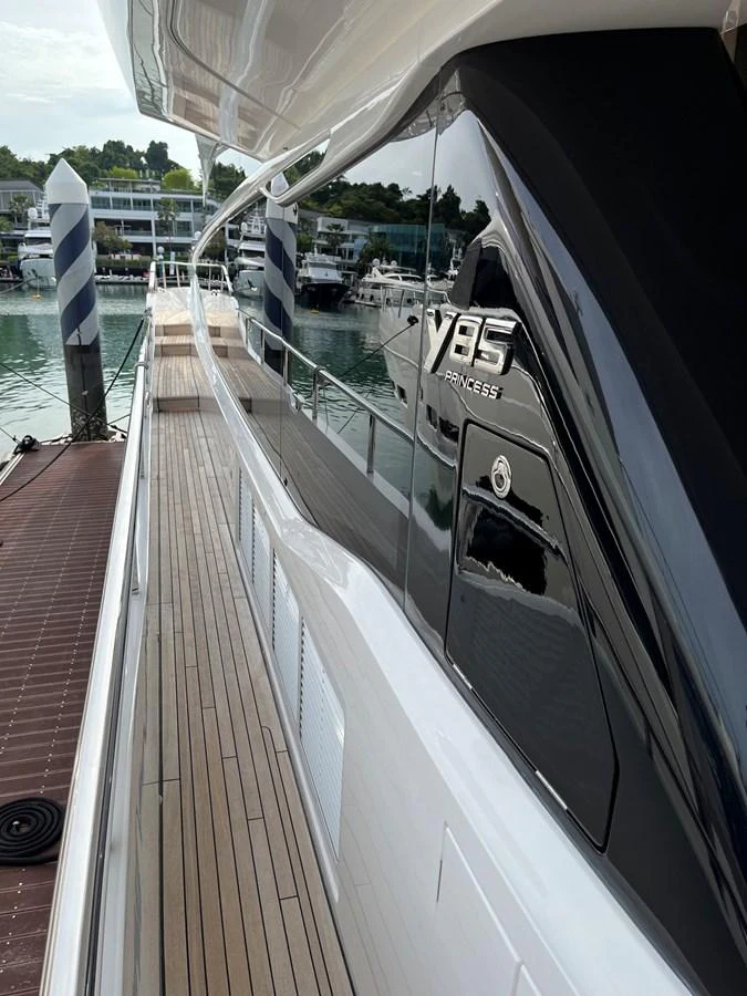 A sleek side deck with polished railings and a view of the marina. aboard LILYAN Yacht for Sale