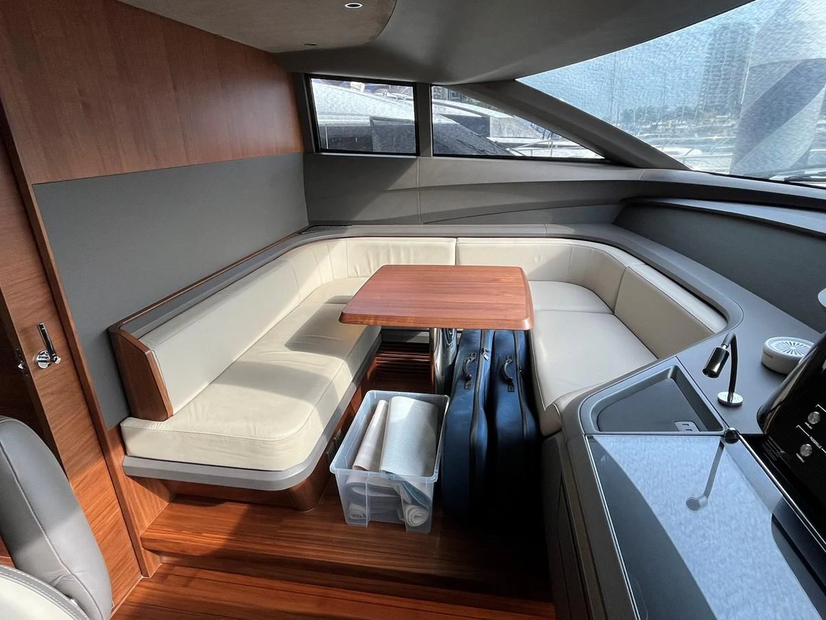 The salon features a cozy seating area with a wooden table and ample natural light. aboard LILYAN Yacht for Sale