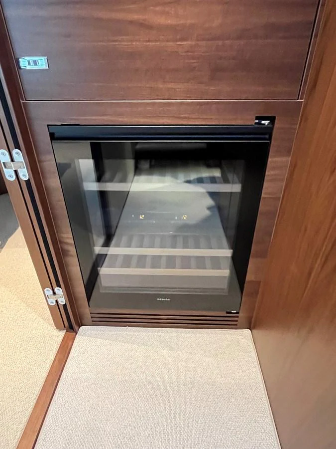 A built-in wine cooler is seamlessly integrated into the yacht's wooden cabinetry. aboard LILYAN Yacht for Sale