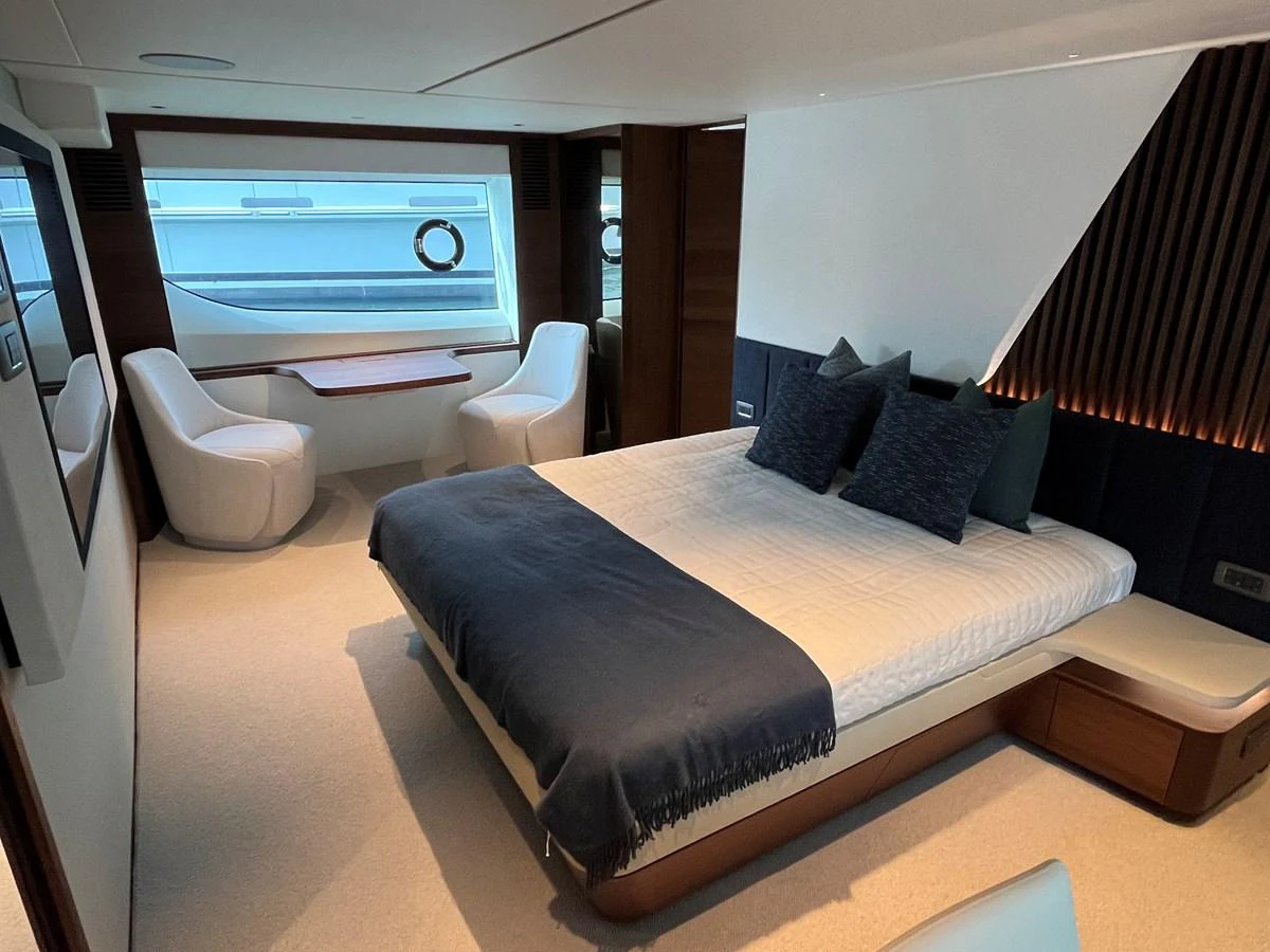 The stateroom features a luxurious bed with elegant seating and ample natural light. aboard LILYAN Yacht for Sale