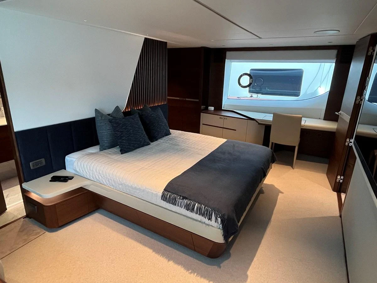 A luxurious stateroom featuring a comfortable bed, modern decor, and a view of the outside through a large window. aboard LILYAN Yacht for Sale