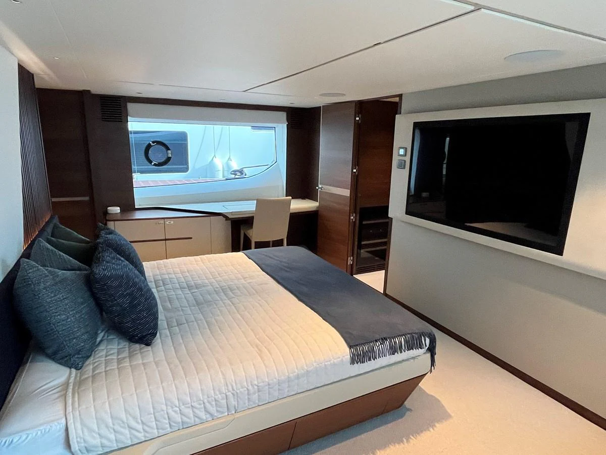 The stateroom features a comfortable bed, a large window, and a flat-screen TV for a luxurious stay. aboard LILYAN Yacht for Sale