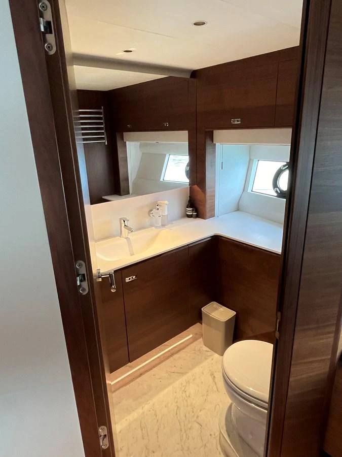 The yacht's bathroom features a sleek design with rich wood finishes and modern fixtures. aboard LILYAN Yacht for Sale