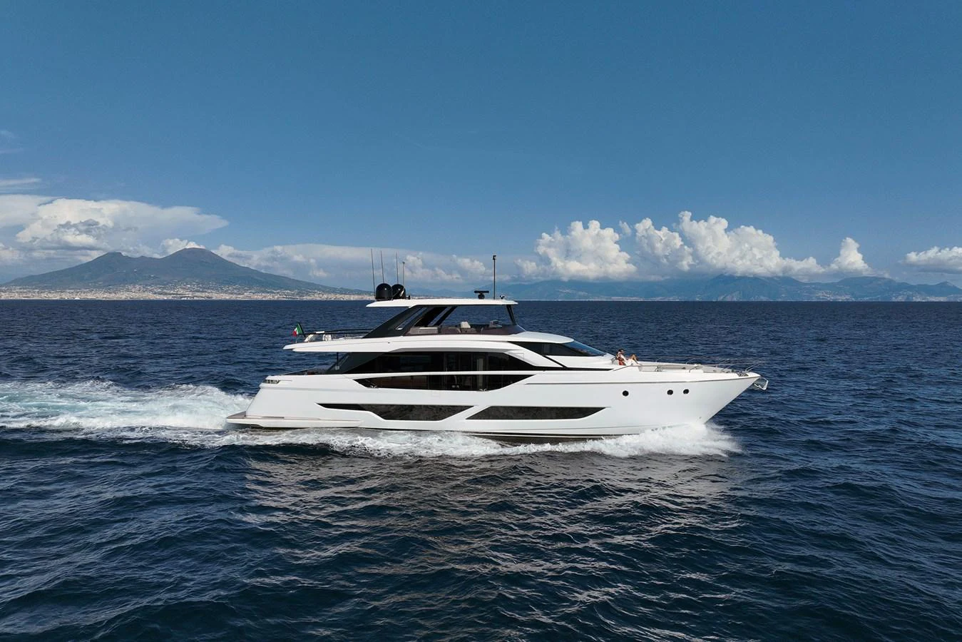 A sleek and modern yacht cruises through the open sea under a clear blue sky. aboard LADY F Yacht for Sale