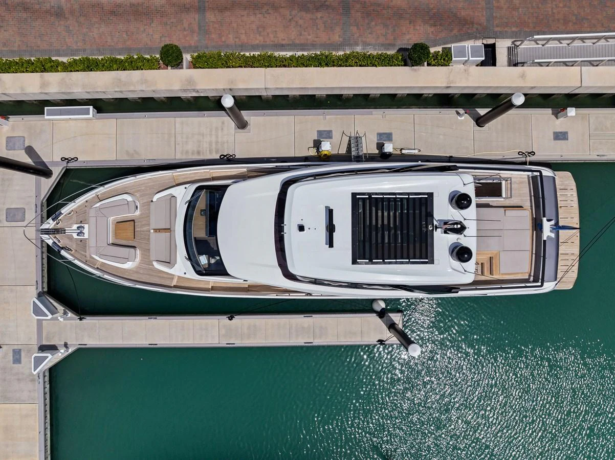 An aerial view of a sleek yacht docked at a marina, showcasing its elegant design and spacious deck areas. aboard LADY F Yacht for Sale