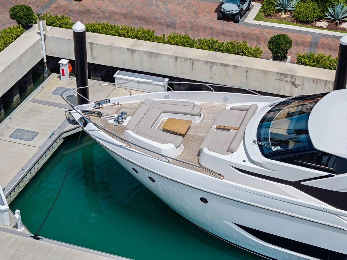 The yacht is docked, showcasing a spacious bow with comfortable seating and a sleek design. aboard LADY F Yacht for Sale