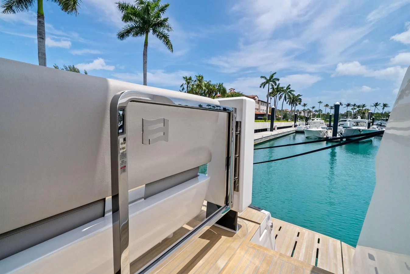 A close-up view of a yacht's boarding gate with a scenic marina backdrop. aboard LADY F Yacht for Sale