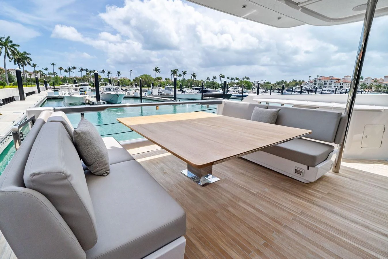 The aft deck features a stylish and comfortable seating area with a wooden table, perfect for alfresco dining. aboard LADY F Yacht for Sale