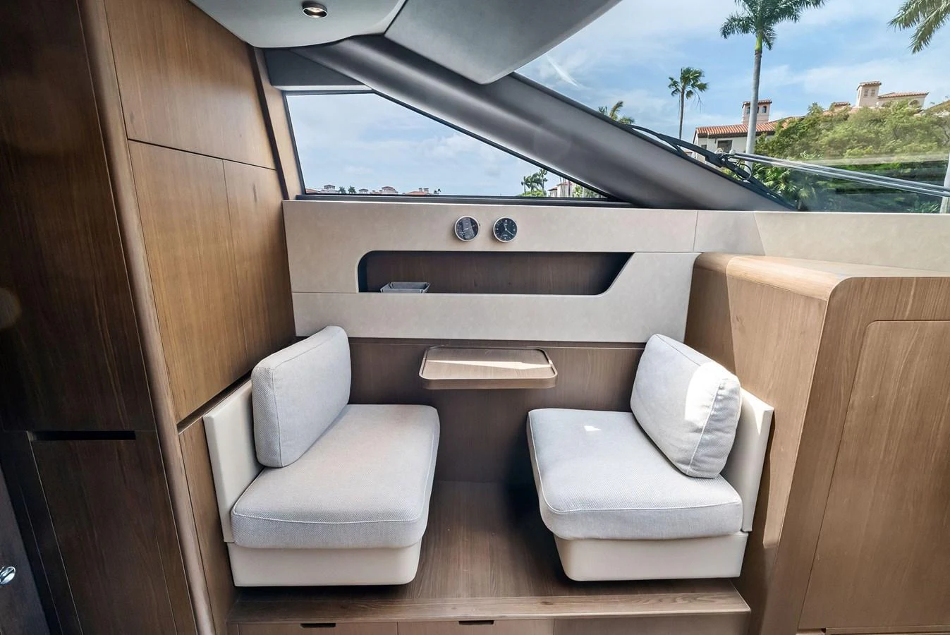 A cozy seating area with two cushioned seats and a small table, perfect for intimate conversations or enjoying the view. aboard LADY F Yacht for Sale