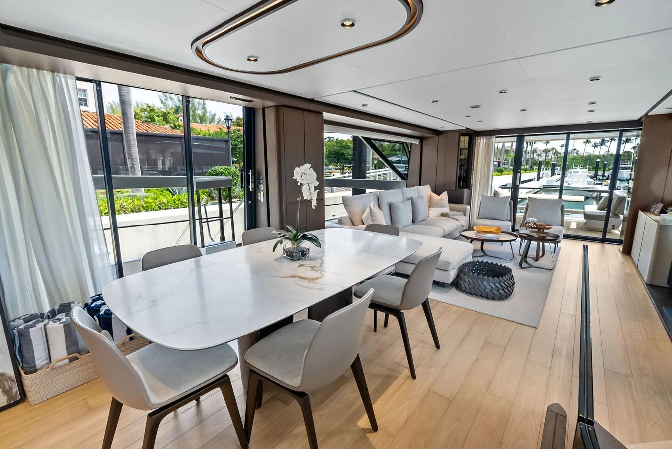 The yacht's salon features a spacious and elegant dining area with a view of the marina. aboard LADY F Yacht for Sale