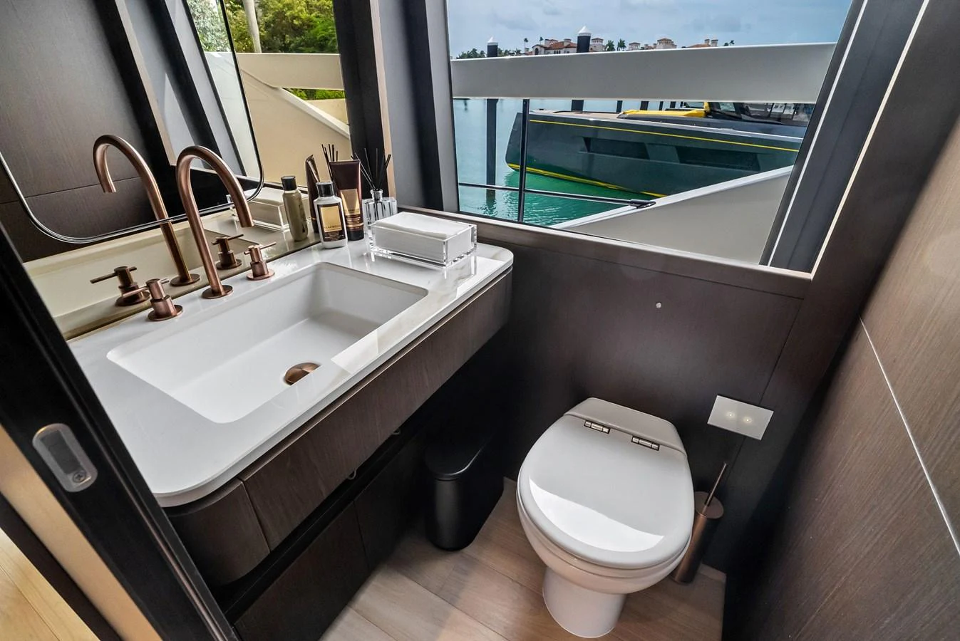 The yacht's head features modern fixtures and a sleek design with a view of the water. aboard LADY F Yacht for Sale