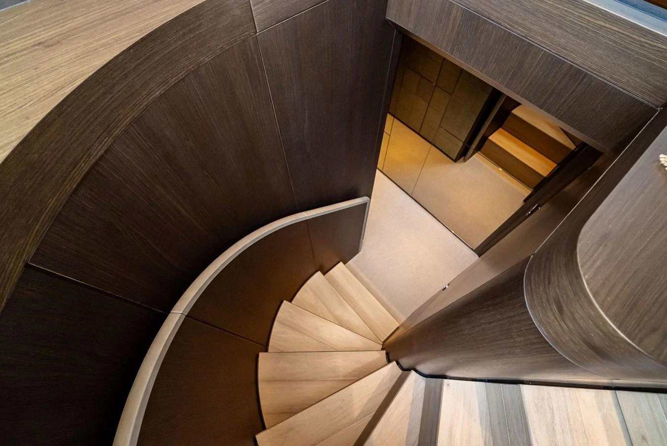 A beautifully designed curved staircase with elegant wooden finishes. aboard LADY F Yacht for Sale