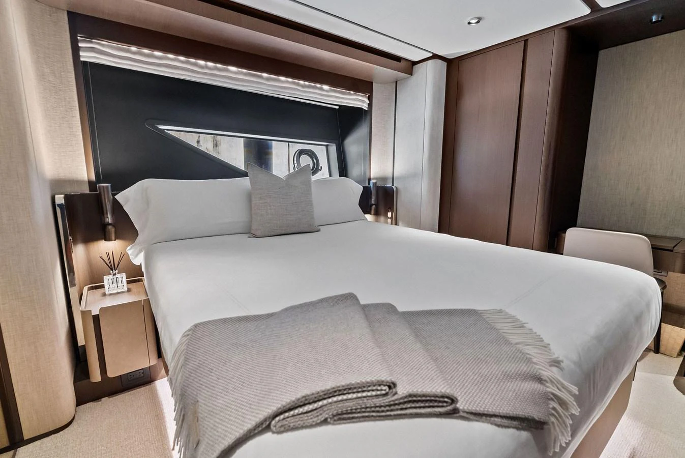 The stateroom features a luxurious bed with elegant linens and modern lighting. aboard LADY F Yacht for Sale
