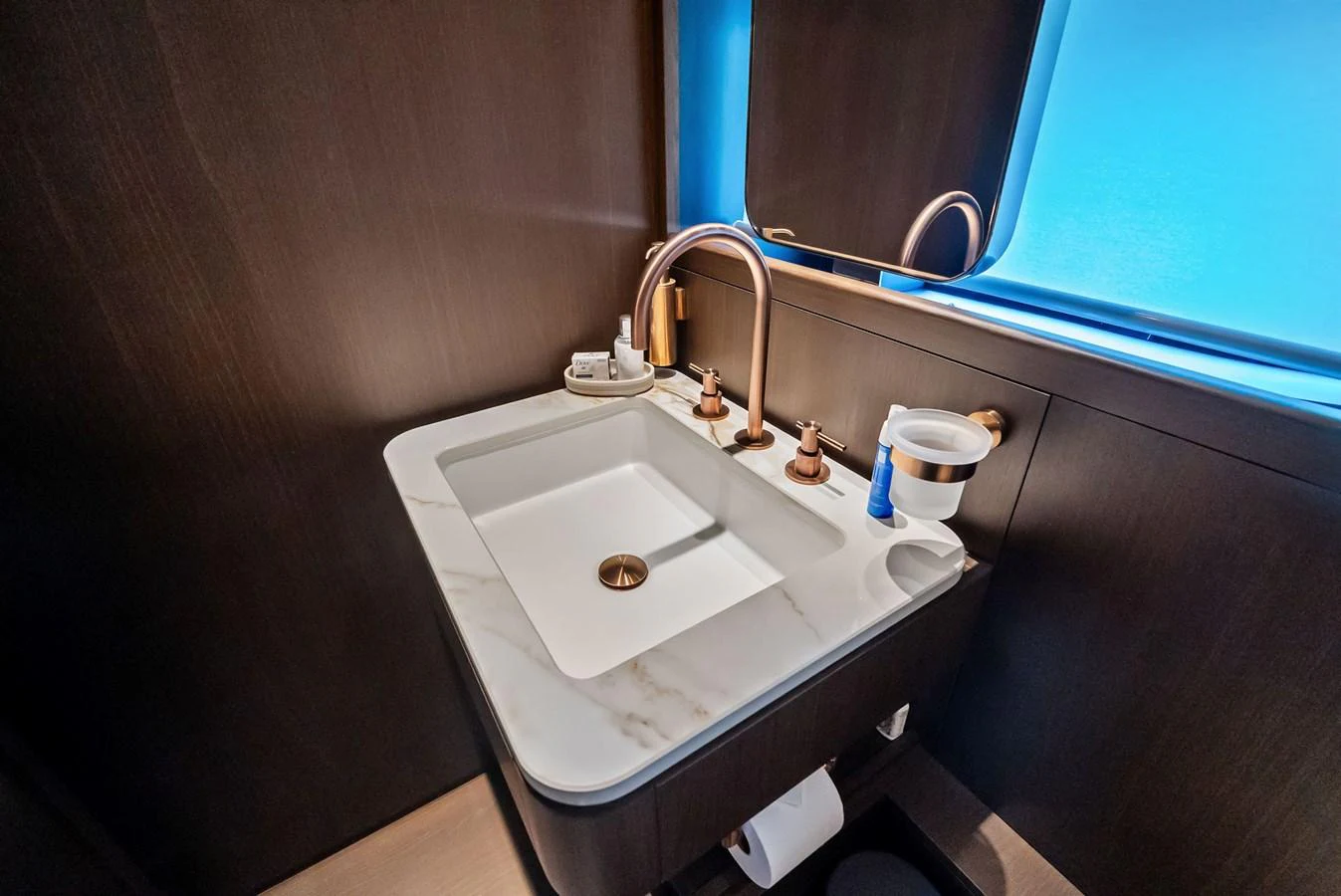 A modern yacht bathroom featuring a sleek sink with elegant fixtures and a large window. aboard LADY F Yacht for Sale
