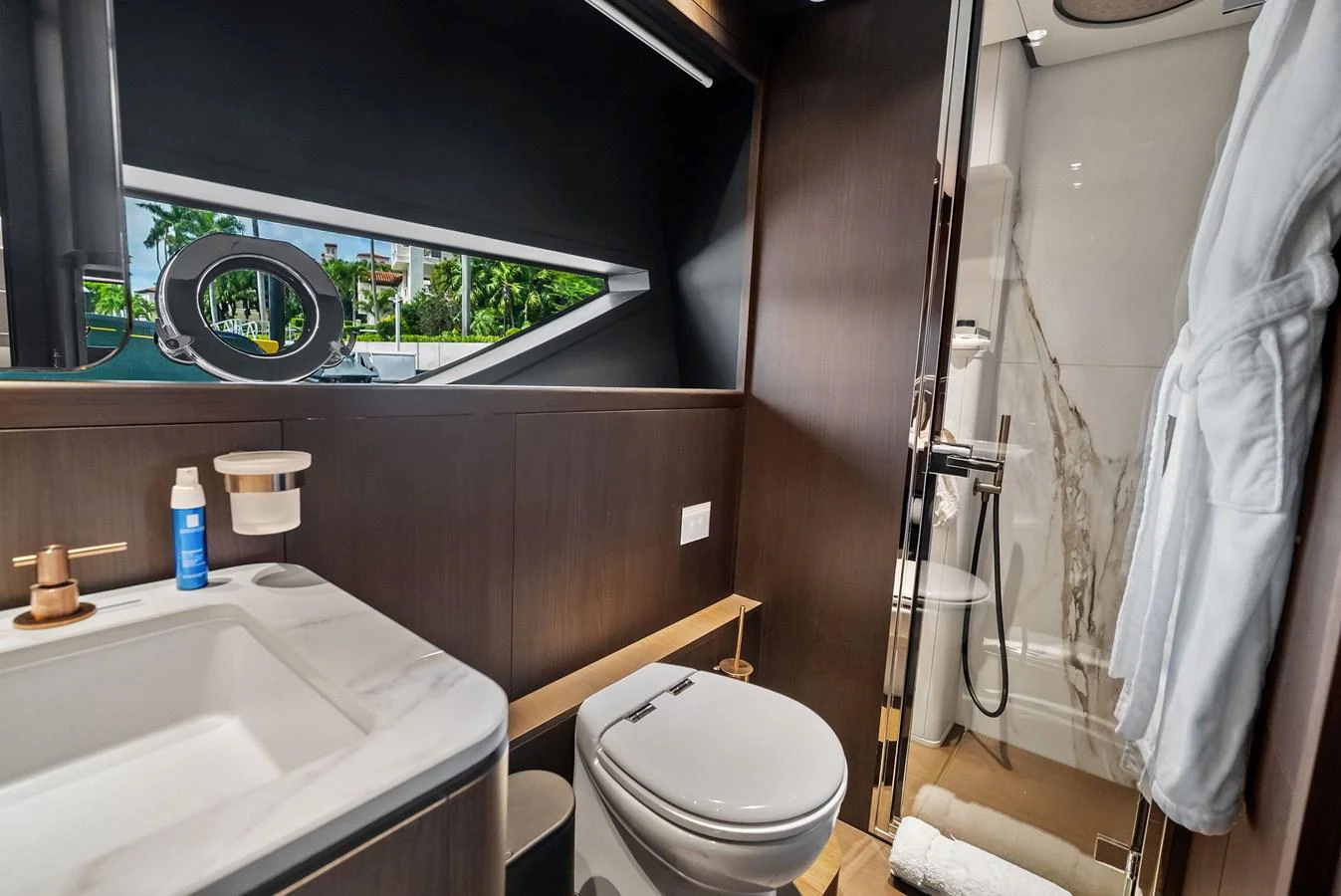 A modern yacht bathroom featuring a sleek design with a shower, toilet, and sink. aboard LADY F Yacht for Sale