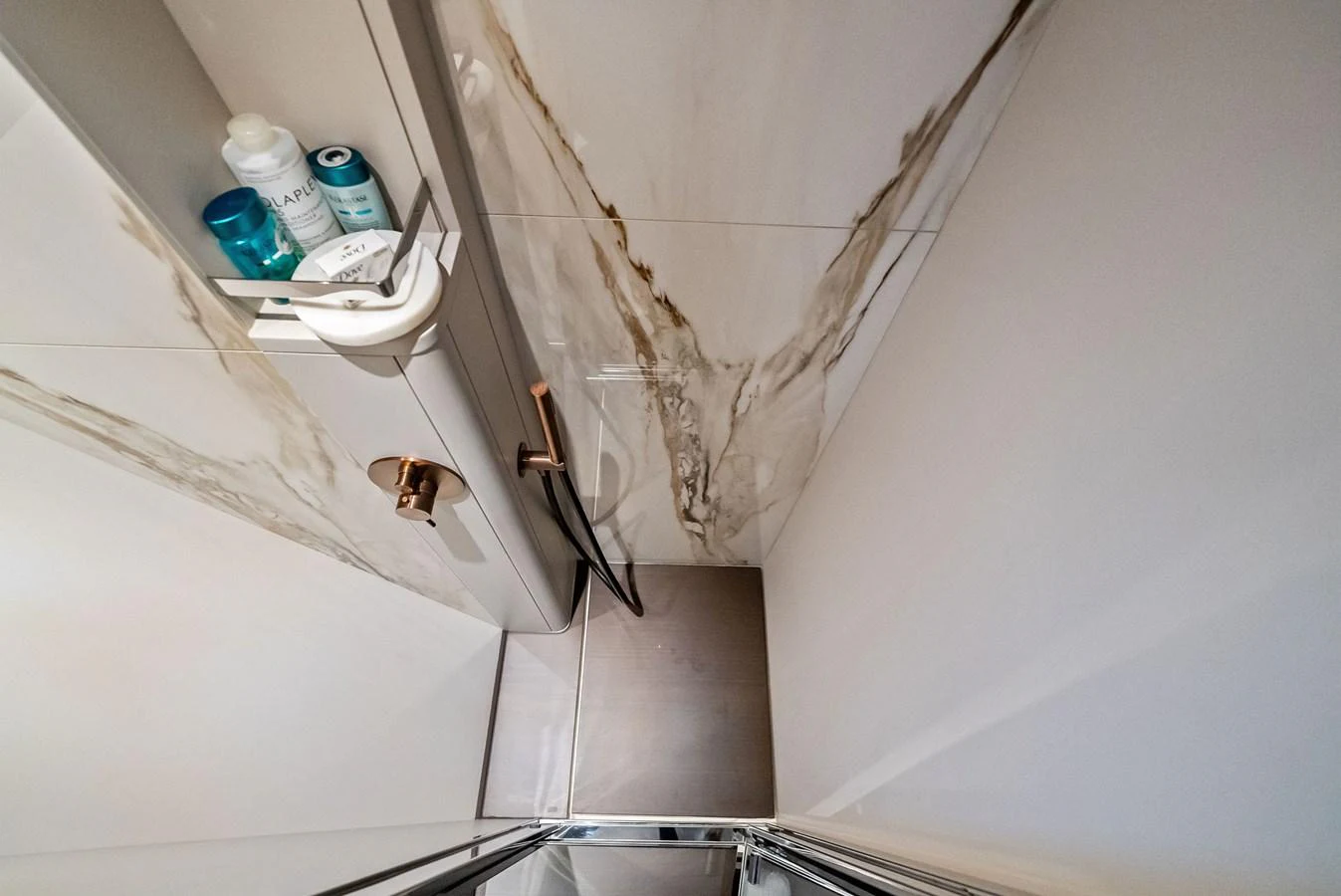 A compact and modern yacht shower with elegant marble accents. aboard LADY F Yacht for Sale