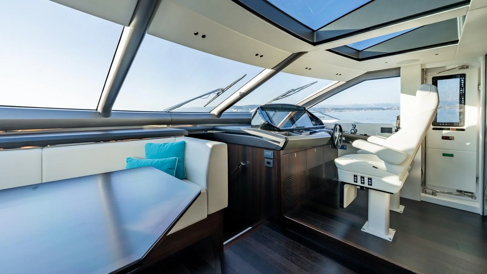 The helm area features modern controls, panoramic windows, and a comfortable seating arrangement. aboard TRIPLE EIGHT Yacht for Sale