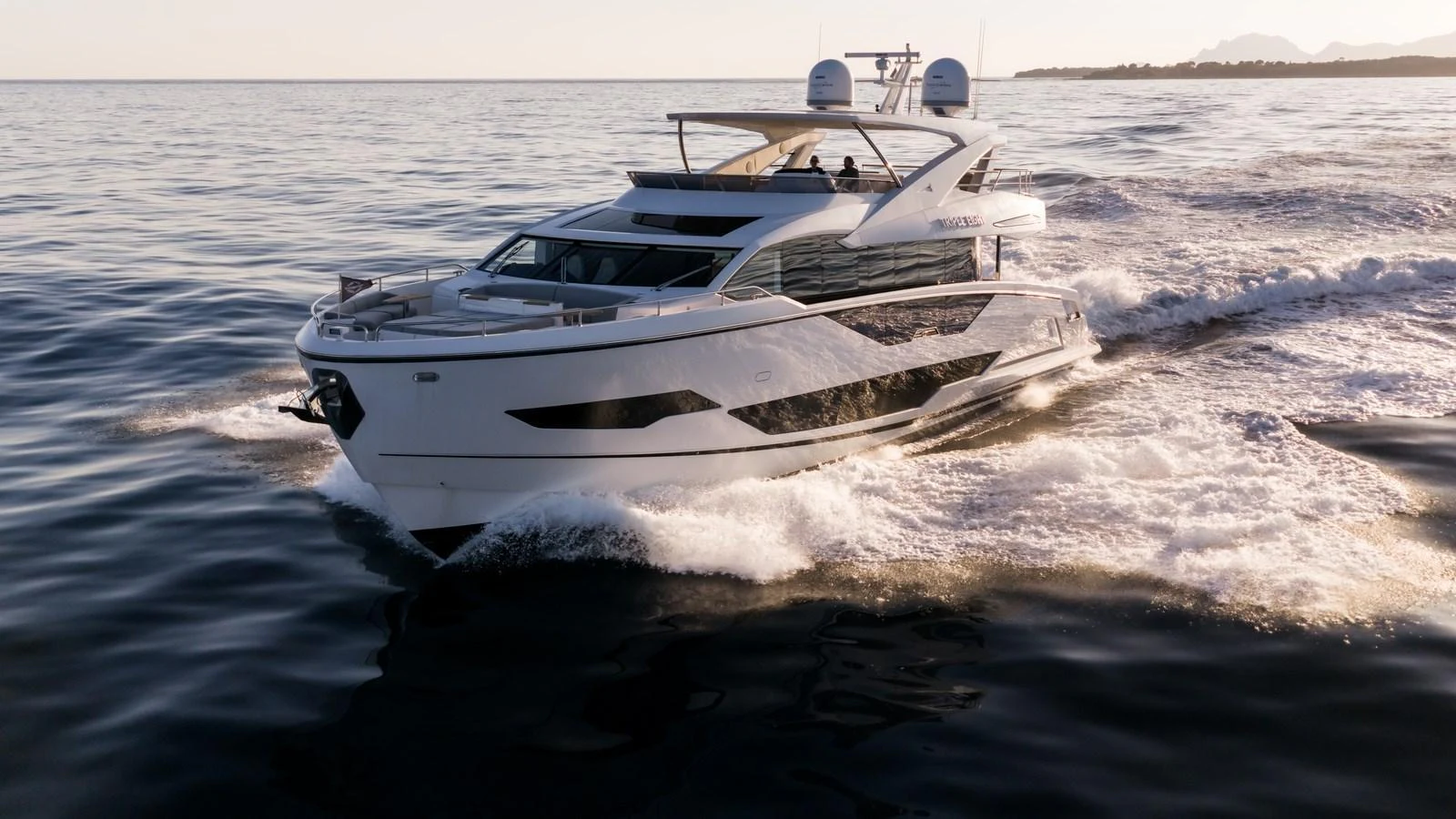 A sleek and modern yacht cruises swiftly through calm waters at sunset. aboard TRIPLE EIGHT Yacht for Sale