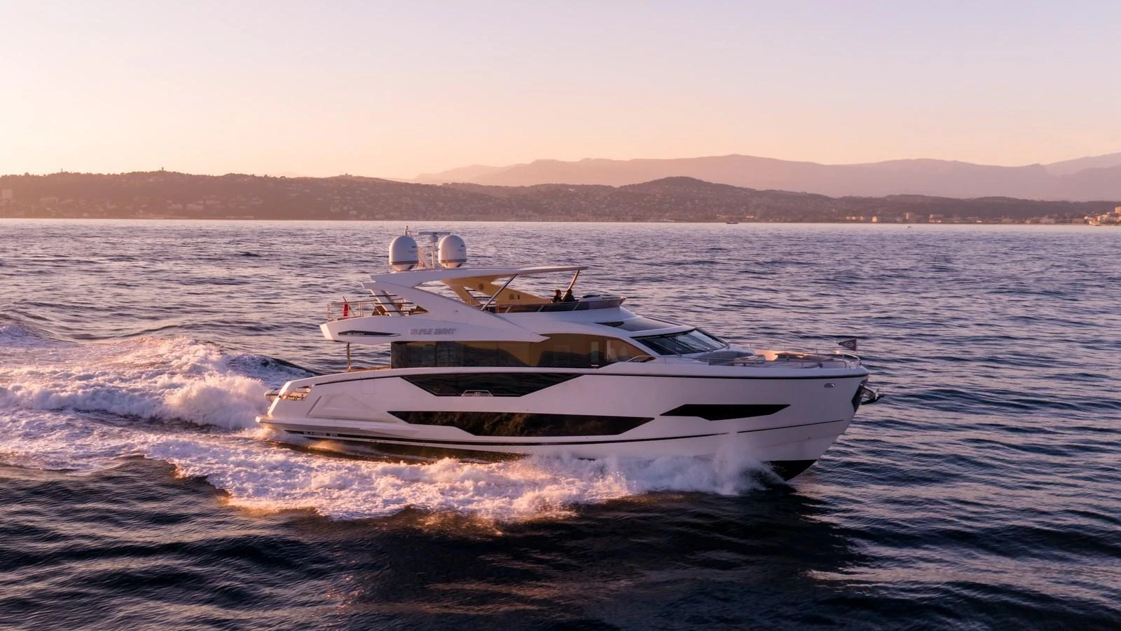 A sleek yacht cruises through calm waters at sunset, showcasing its elegant design and powerful performance. aboard TRIPLE EIGHT Yacht for Sale