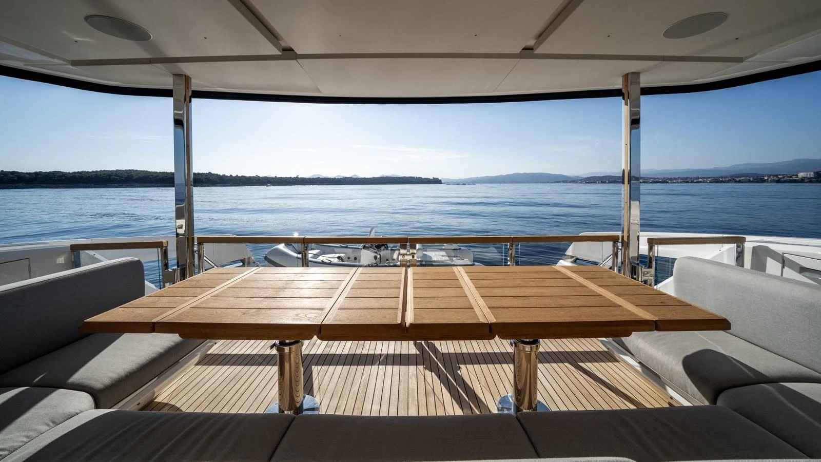 The aft deck offers a spacious and serene area with a large wooden table and comfortable seating, perfect for enjoying the view of the water. aboard TRIPLE EIGHT Yacht for Sale