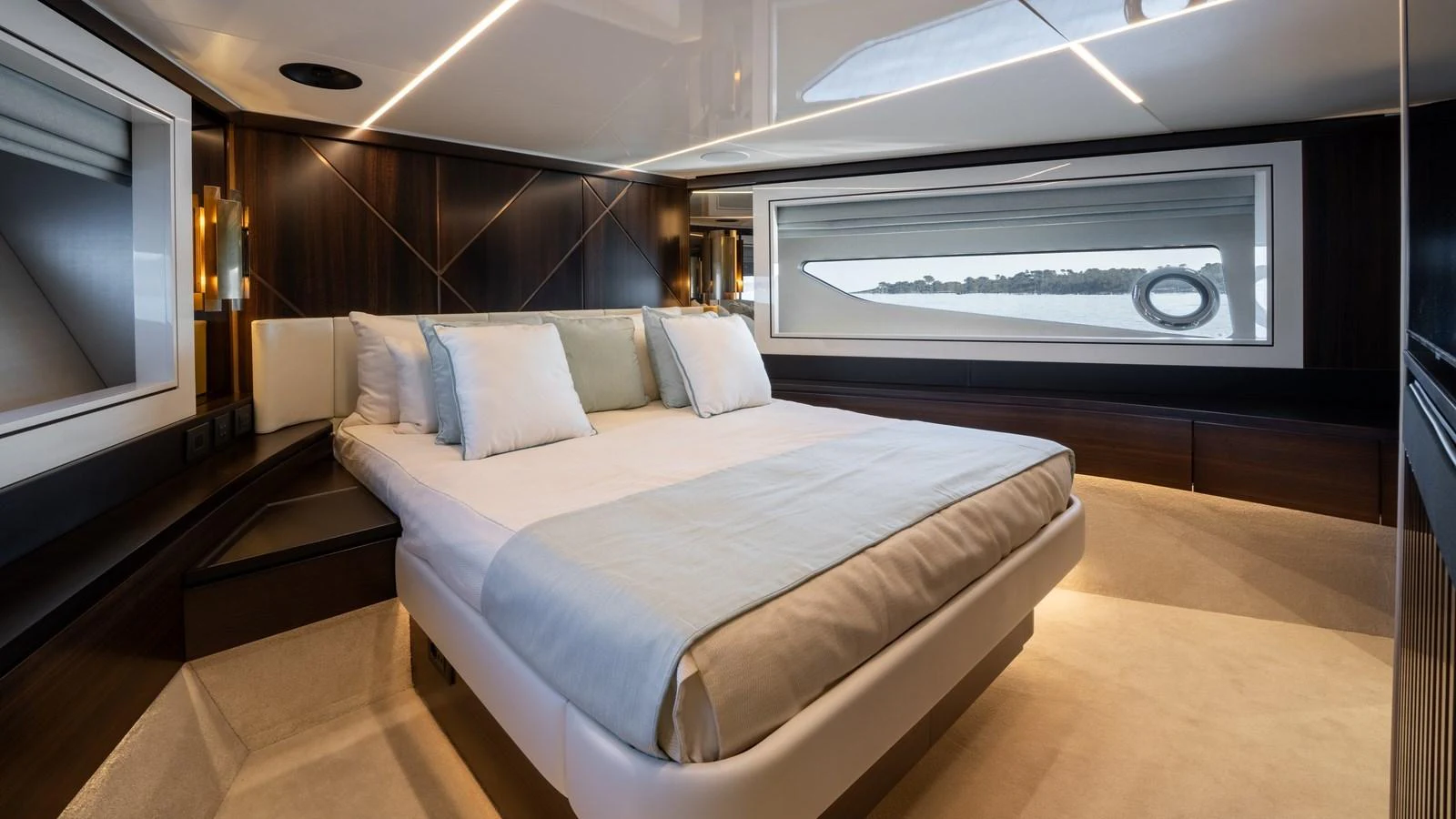 The stateroom features a luxurious bed with elegant lighting and a large window offering a scenic view. aboard TRIPLE EIGHT Yacht for Sale