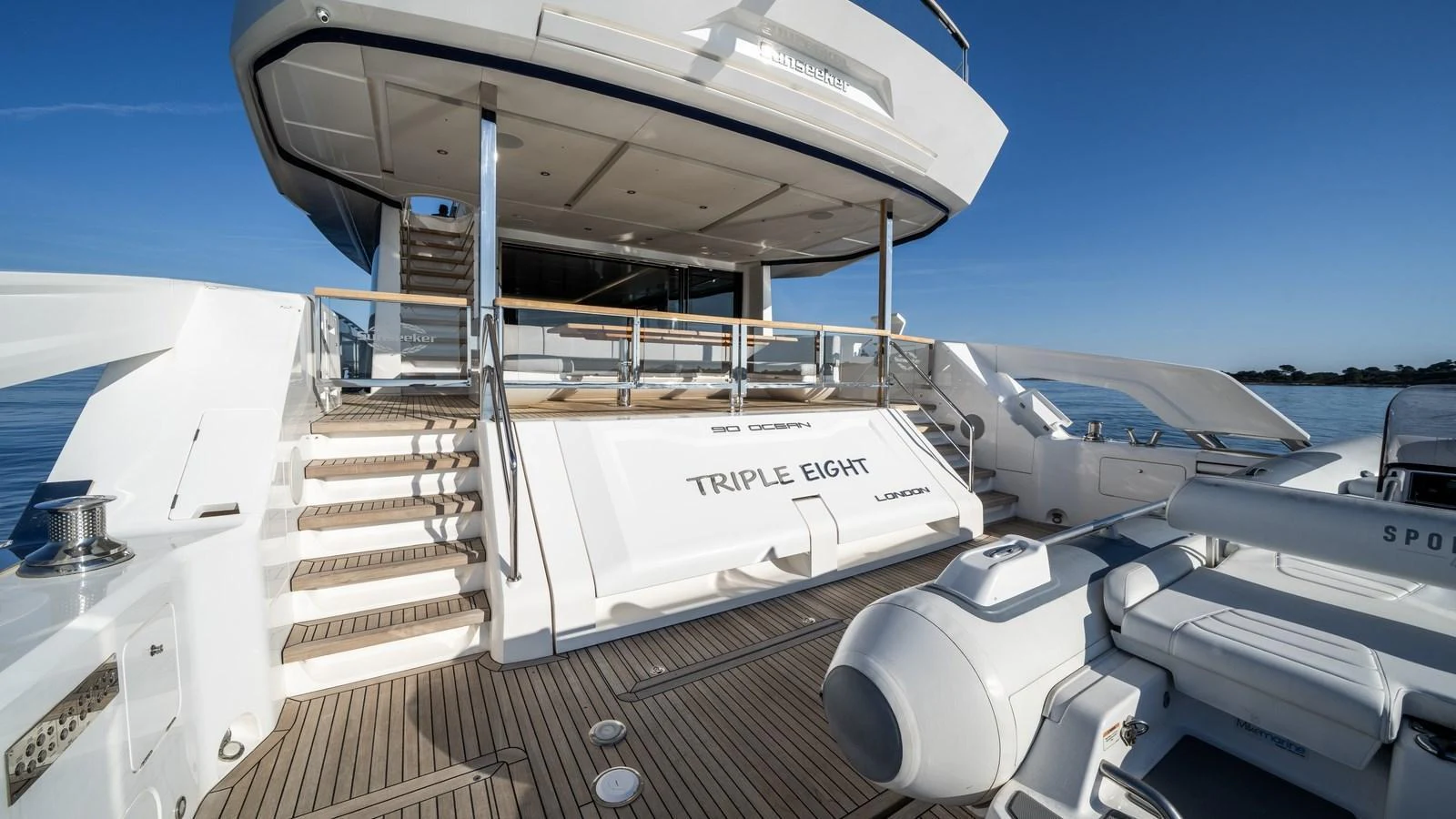 The yacht's aft deck features a spacious and inviting area with elegant stairs leading to the upper deck. aboard TRIPLE EIGHT Yacht for Sale