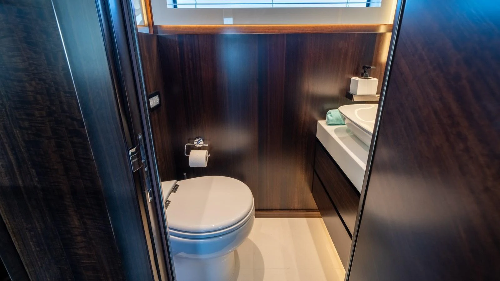 The yacht's head features a modern and compact design with dark wood paneling and a sleek sink area. aboard TRIPLE EIGHT Yacht for Sale