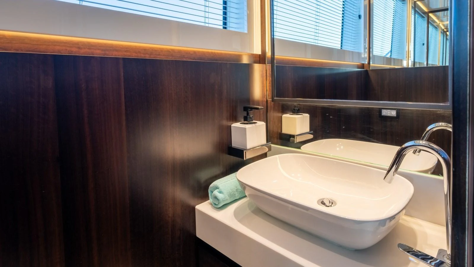 The yacht's bathroom features a sleek, modern design with a stylish sink and elegant wood paneling. aboard TRIPLE EIGHT Yacht for Sale