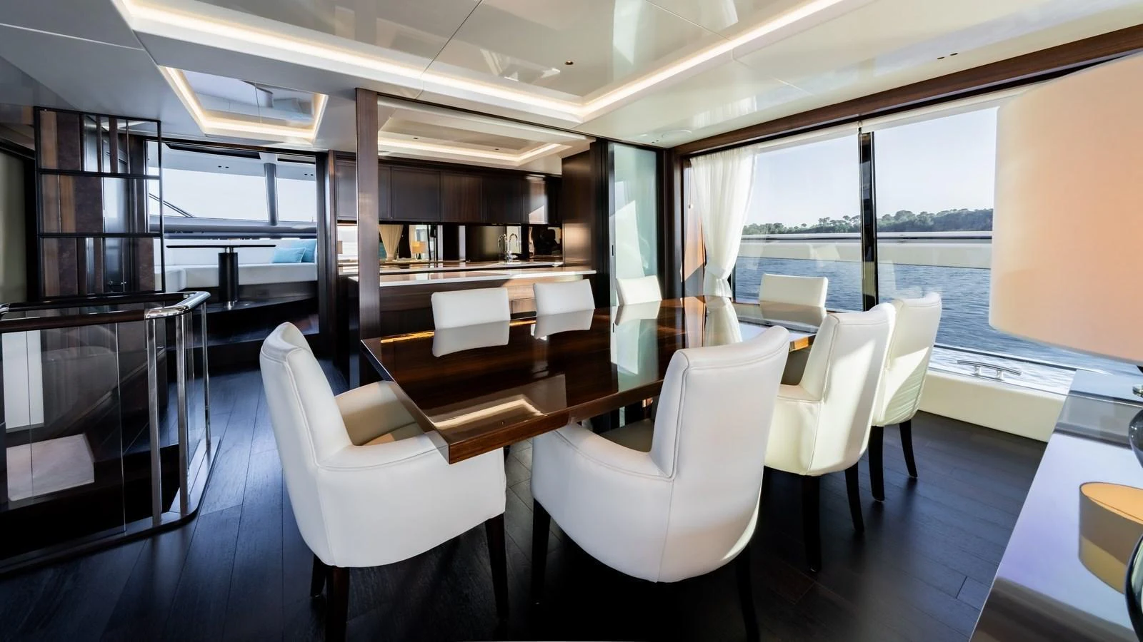 The yacht's dining area features elegant seating with a stunning view of the water through large windows. aboard TRIPLE EIGHT Yacht for Sale